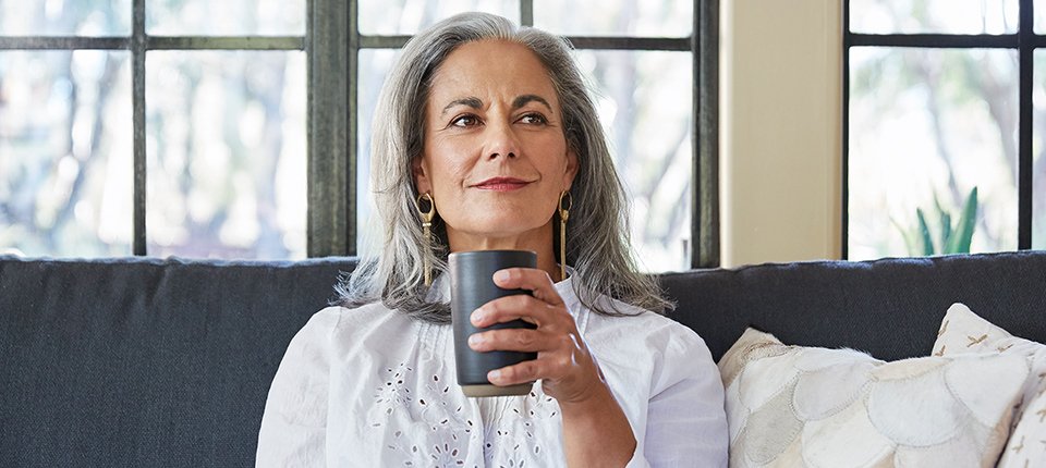 A doctor explaining medical and natural treatment options for essential tremor to a patient, including medication icons and natural herbal remedies.